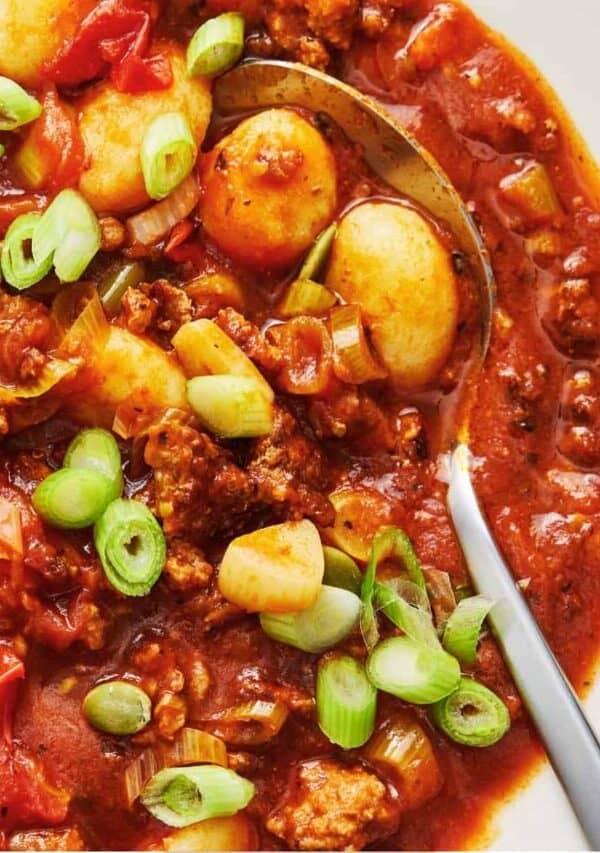 Overhead image of Gnocchi Bolognese in a white bowl with a spoon