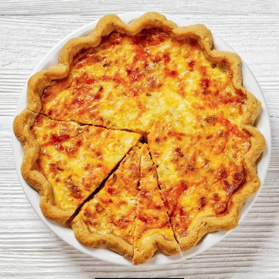 Bacon Quiche in a white pie dish cut into slices