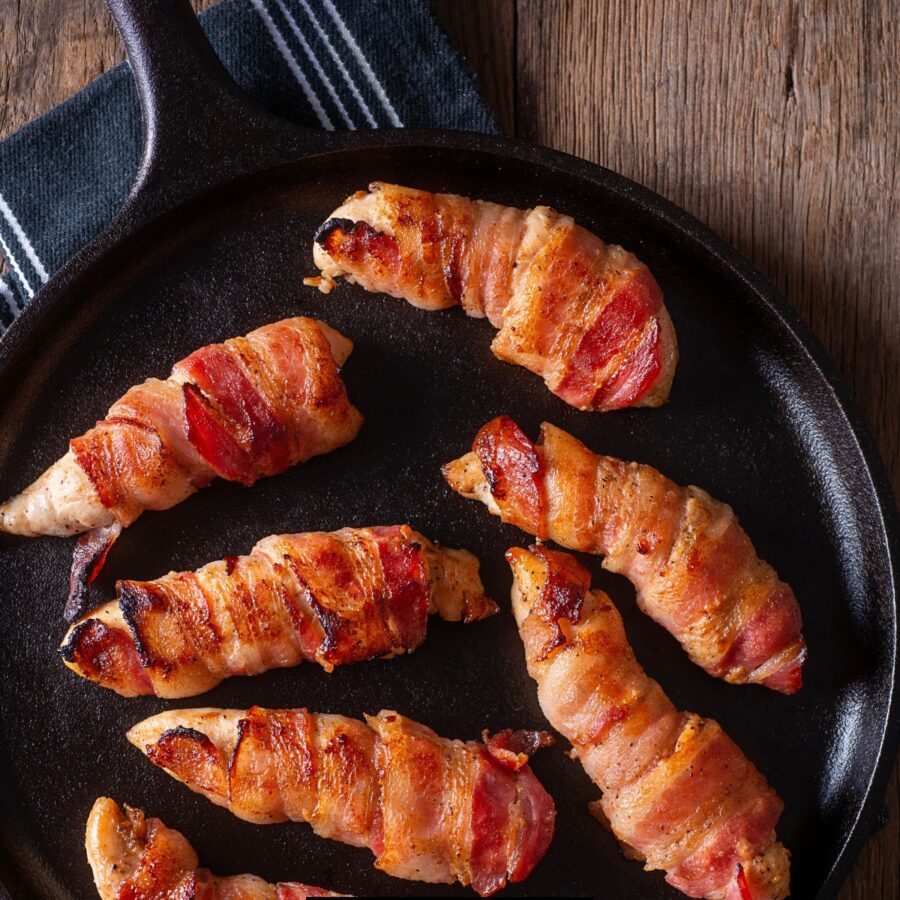 Close up image of Bacon Wrapped Chicken Tenders in a skillet