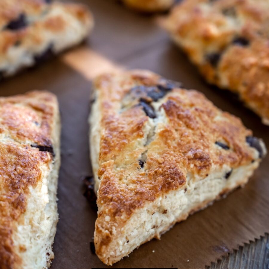 Close up image of chocolate chip scones on a wooden cutting board