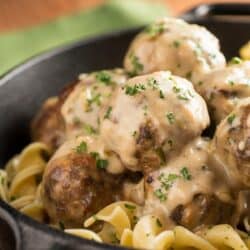 Close up image of crock pot swedish meatballs on egg noodles in a bowl