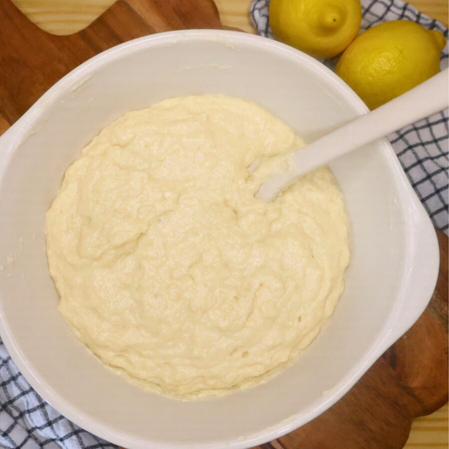 Lemon Muffin batter in a mixing bowl with a silicone spatula