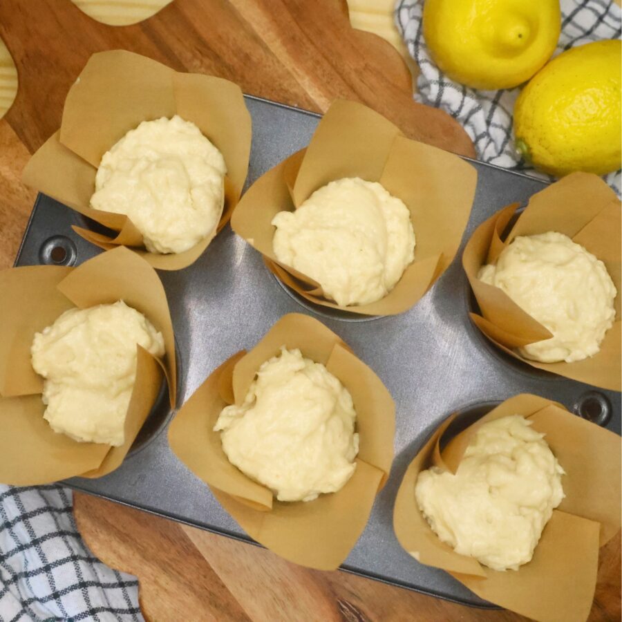 Lemon Muffin batter in a muffin tin with paper liners