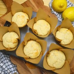 Six baked lemon muffins in a muffin tin