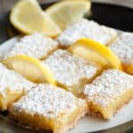 Overhead image of Lemon Squres on a white plate with lemon wedges - 7
