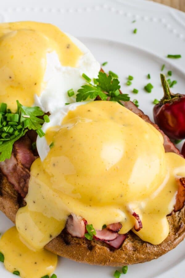 Close up image of Eggs Benedict on a white plate