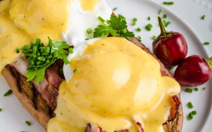 Close up image of Eggs Benedict on a white plate