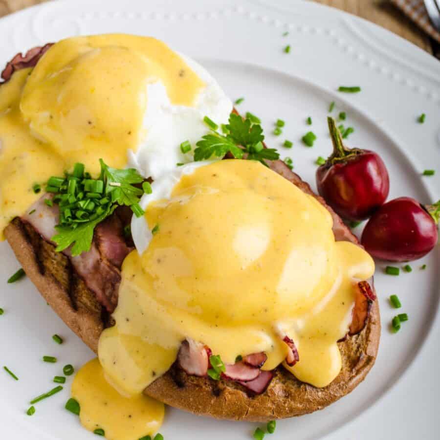 Close up image of Eggs Benedict on a white plate