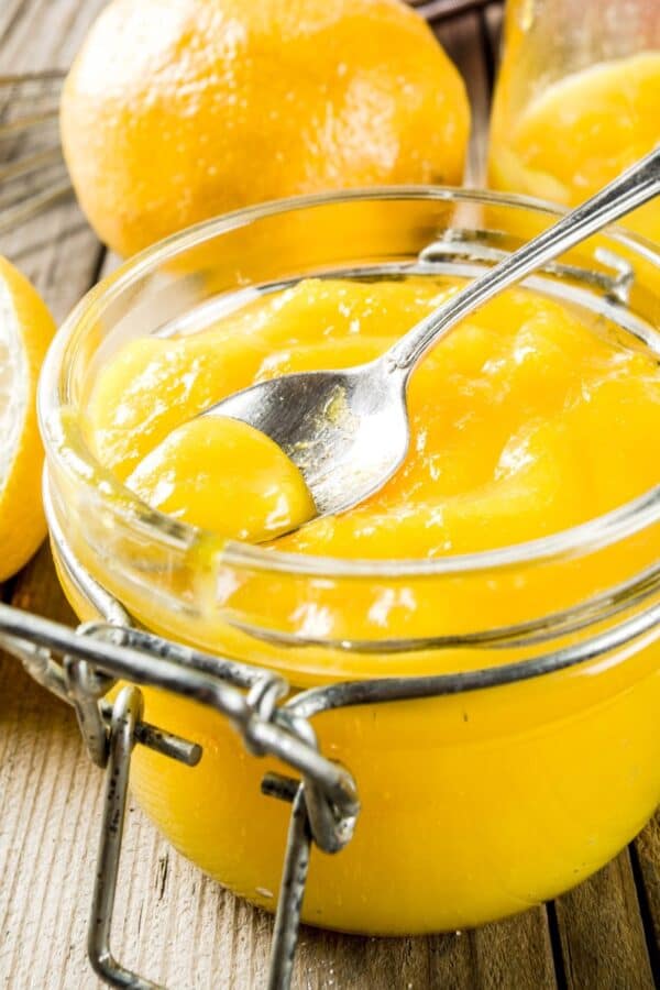 Lemon Curd in a glass jar with a spoon in it