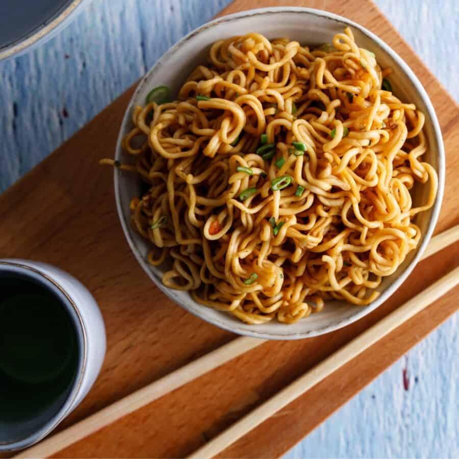 Teriyaki Noodles in a bowl with a sauce bowl next to it