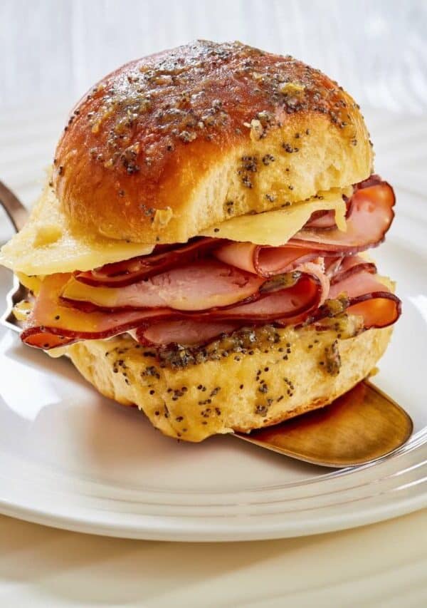 Close up image of a Hawaiian roll slider being served on a white place