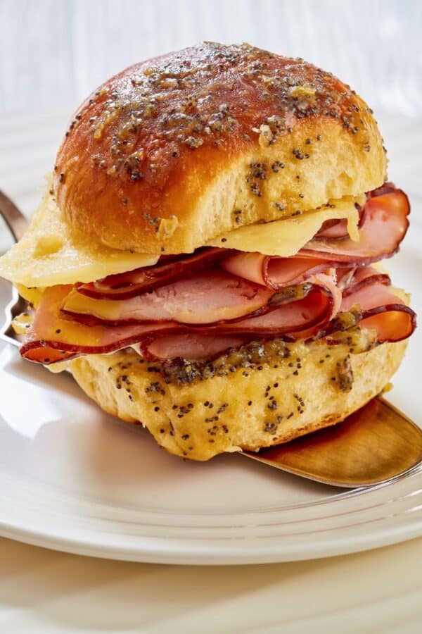 Close up image of a Hawaiian roll slider being served on a white place