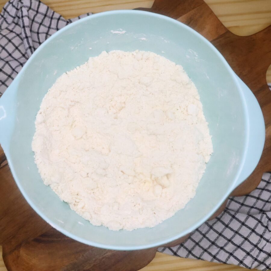 Butter cut into dry ingredients for blueberry scones