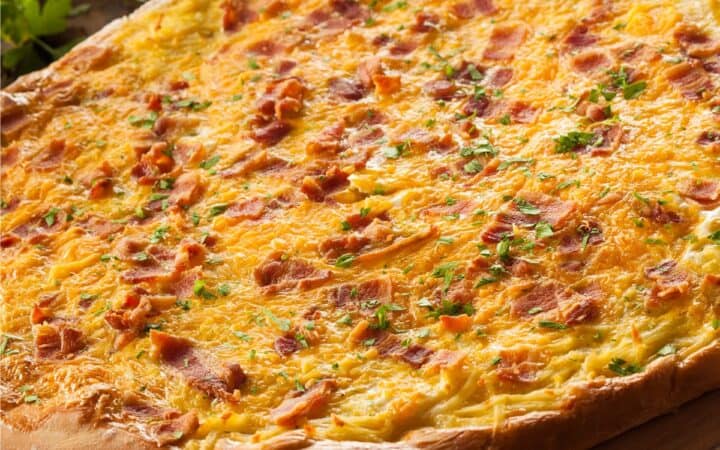 Bacon Egg and Cheese Breakfast Pizza on a wooden surface