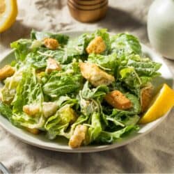 Caesar Salad on a white plate with a rustic background