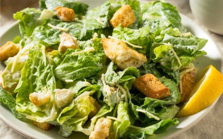 Caesar Salad on a white plate with a rustic background