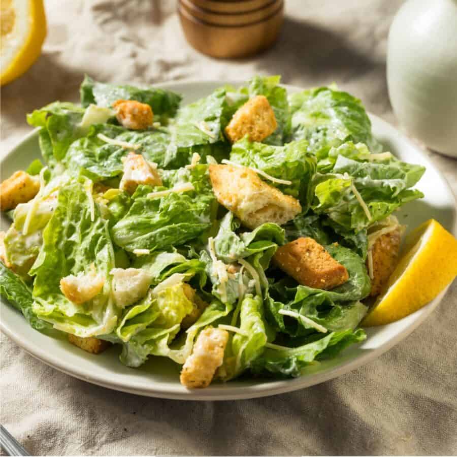 Caesar Salad on a white plate with a rustic background