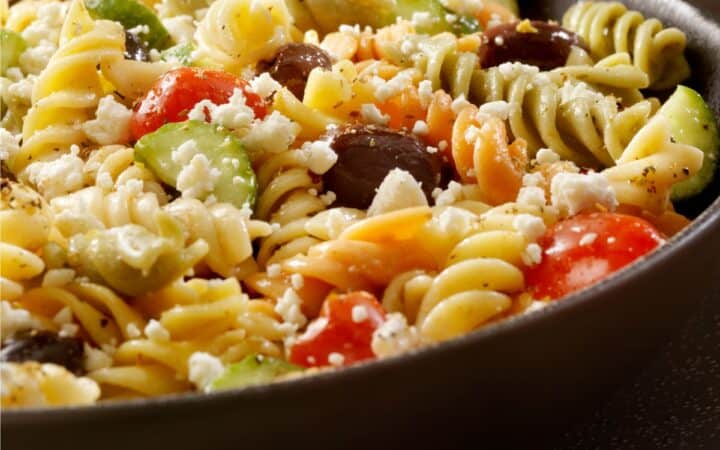 Close up image of Greek Pasta Salad in a black bowl