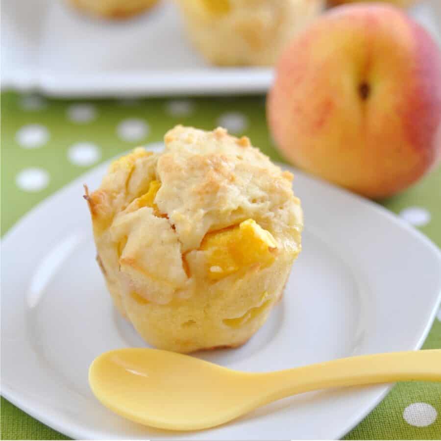 Close up image of peach muffins on a white plate