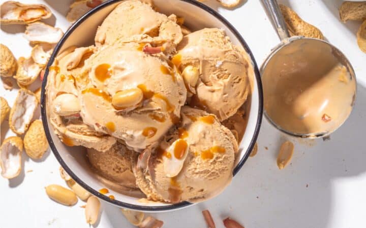 Overhead image of Peanut Butter Ice Cream in a bowl with peanuts scattered around it