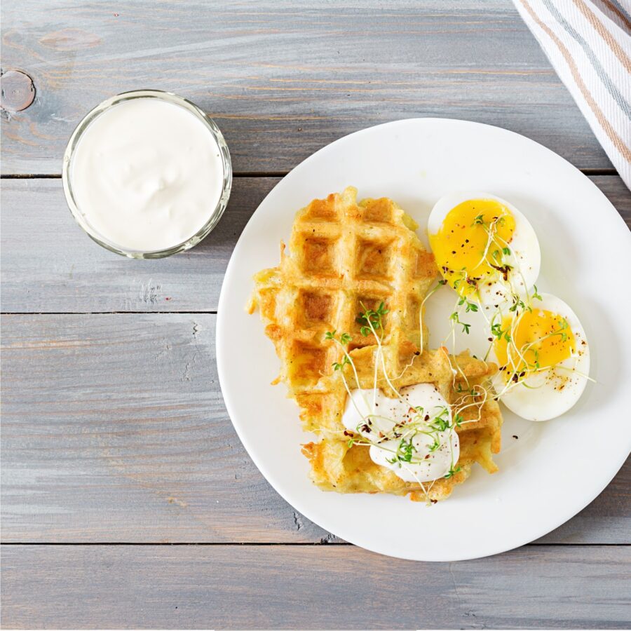 Close up image of Potato Waffles with over easy eggs