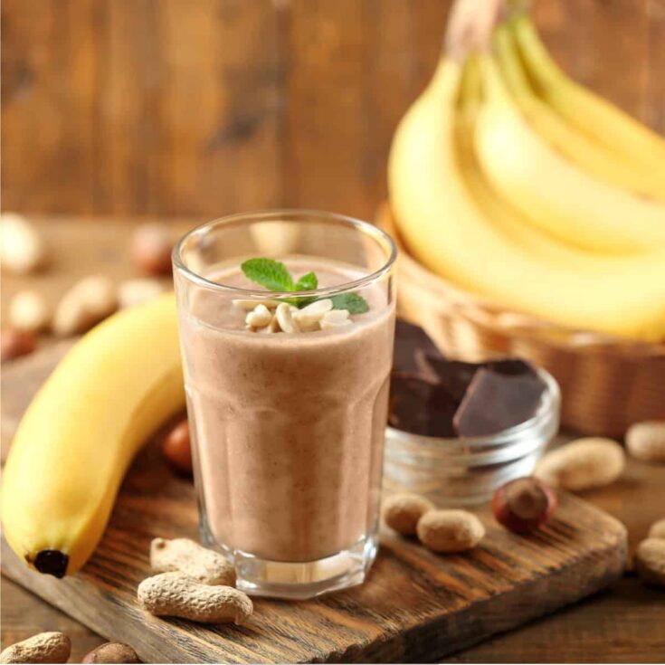 Protein Smoothie on a rusting table with peanuts and bananas