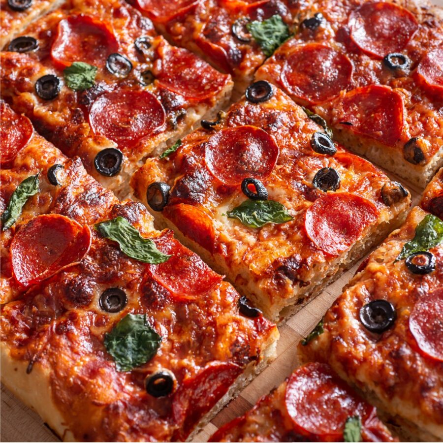 Close up image of a sheet pan pizza cut into pieces