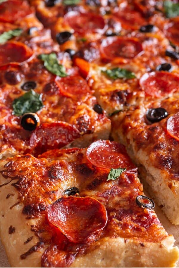 Sheet Pan Pizza cut into pieces on a parchment paper