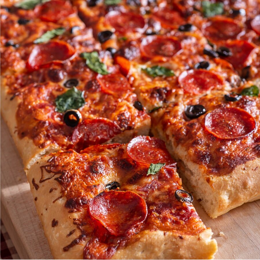 Sheet Pan Pizza cut into pieces on a parchment paper