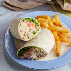 Overhead image of a Tuna Wrap cut in half on a blue and white plate