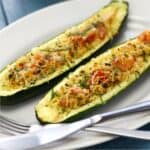 Two Zucchini Boats on a white plate with silverware - 8