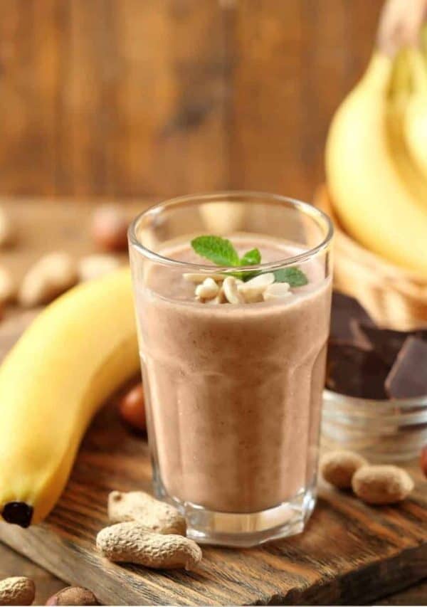 Protein Smoothie on a rusting table with peanuts and bananas