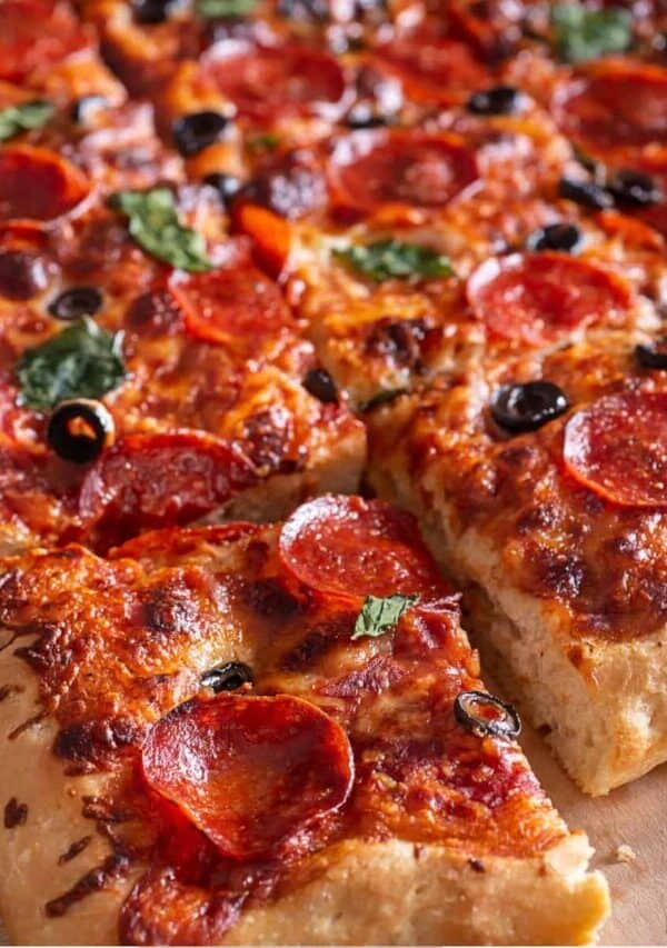 Sheet Pan Pizza cut into pieces on a parchment paper