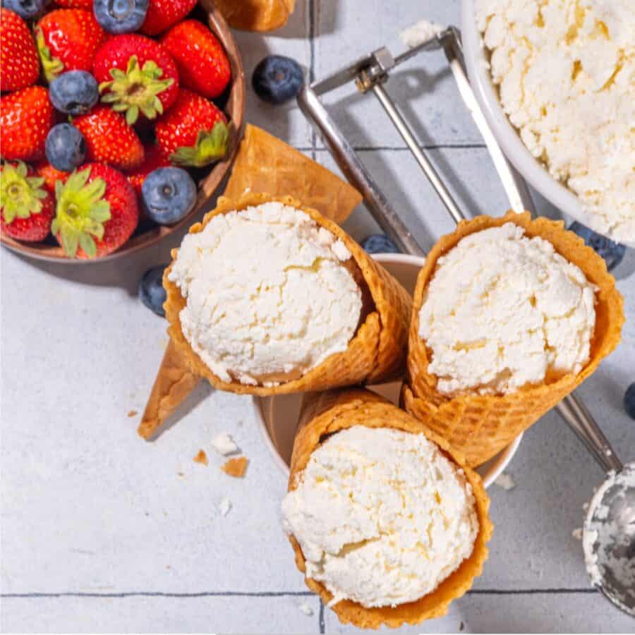 Overhead image of three Cottage Cheese Ice Cream Cones with a bowl of fruit