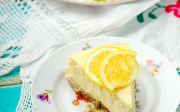 A slice of lemon cheesecake on a decorative plate