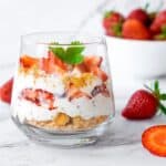 A single serving Strawberry Trifle in a glass bowl with strawberries surrounding it - 13