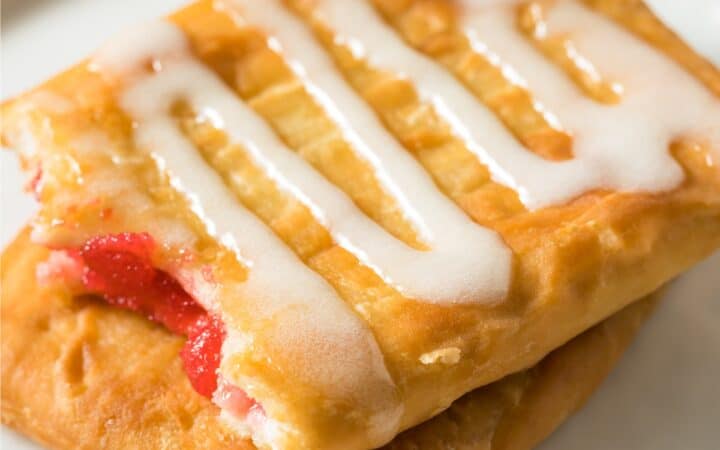 Close up overhead image of two Toaster Strudels stacked on a plate with icing