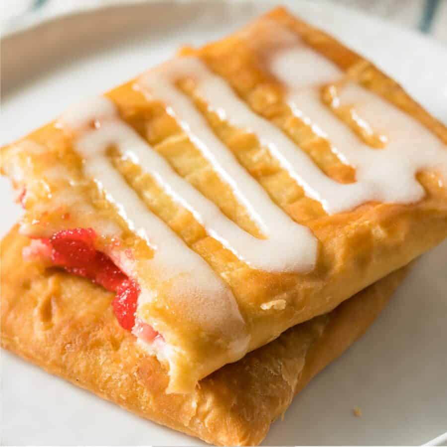 Close up overhead image of two Toaster Strudels stacked on a plate with icing