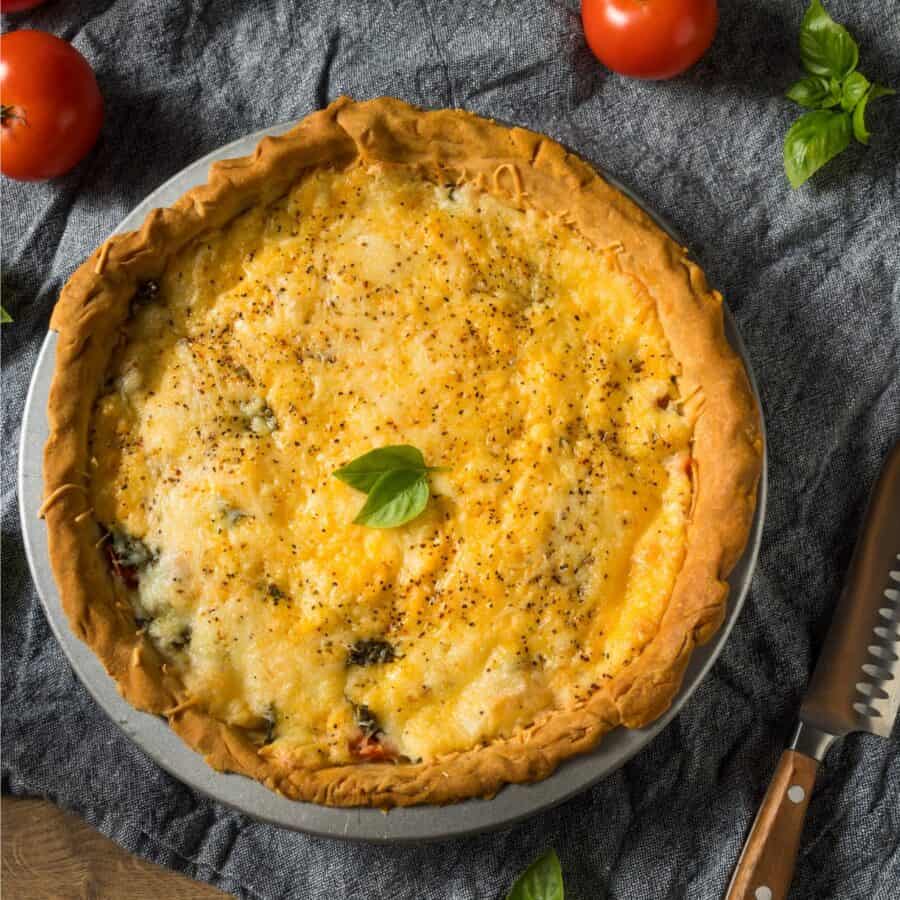 Overhead image of a Tomato Pie on a blue cloth