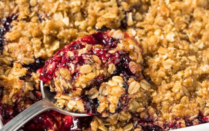 Blackberry Crisp in a white pan with a spoon in it