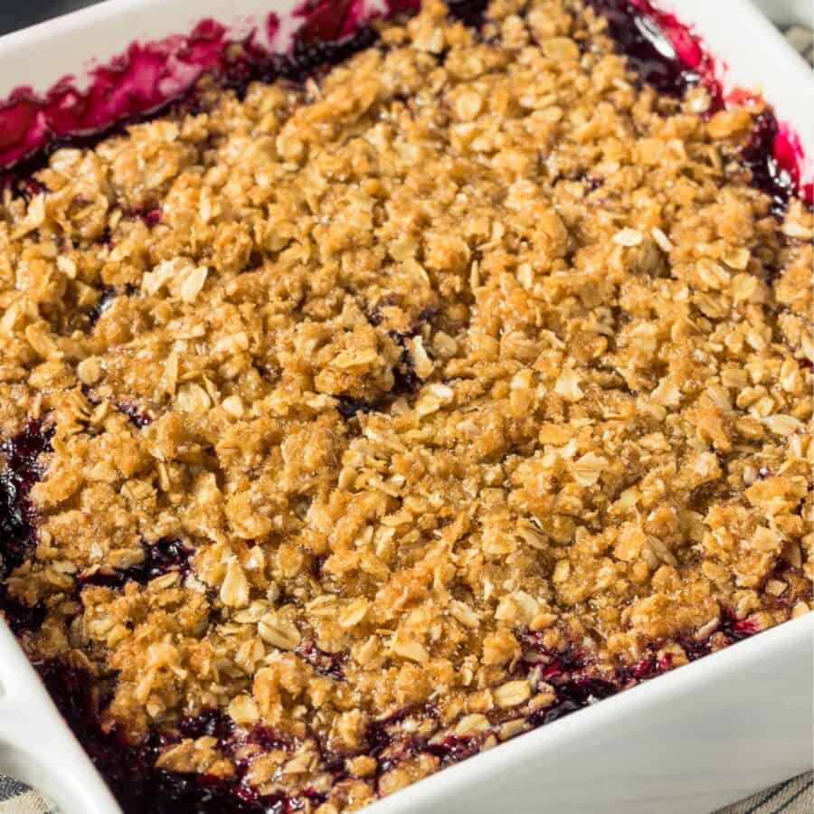 Close up image of blackberry crisp in a white casserole dish