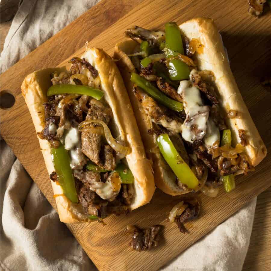 Overhead image of two Blackstone Philly Cheesesteaks on a wooden cutting board