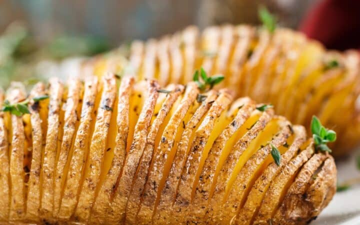 Two Hasselback Potatoes on a white plate