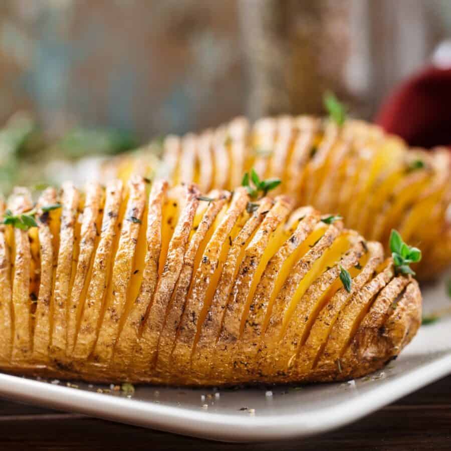 Two Hasselback Potatoes on a white plate