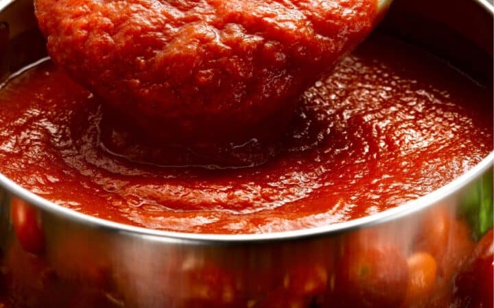 Homemade Pizza Sauce in a bowl being served with a spoon