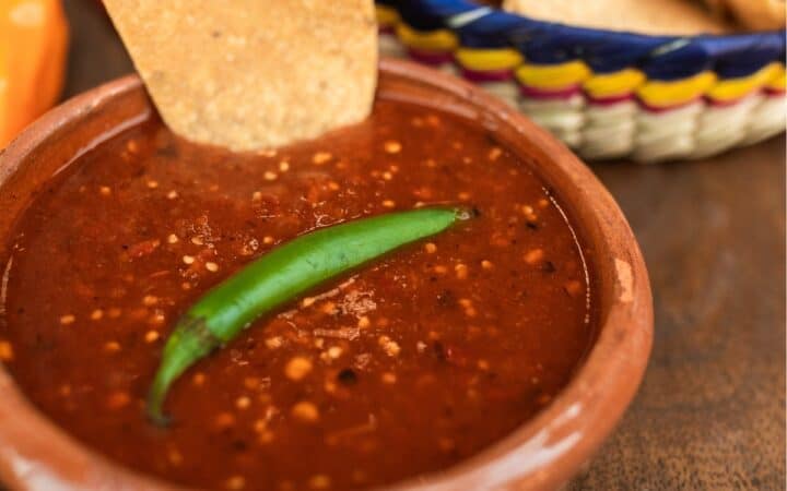 Salsa Roja in a bowl with chips in the background