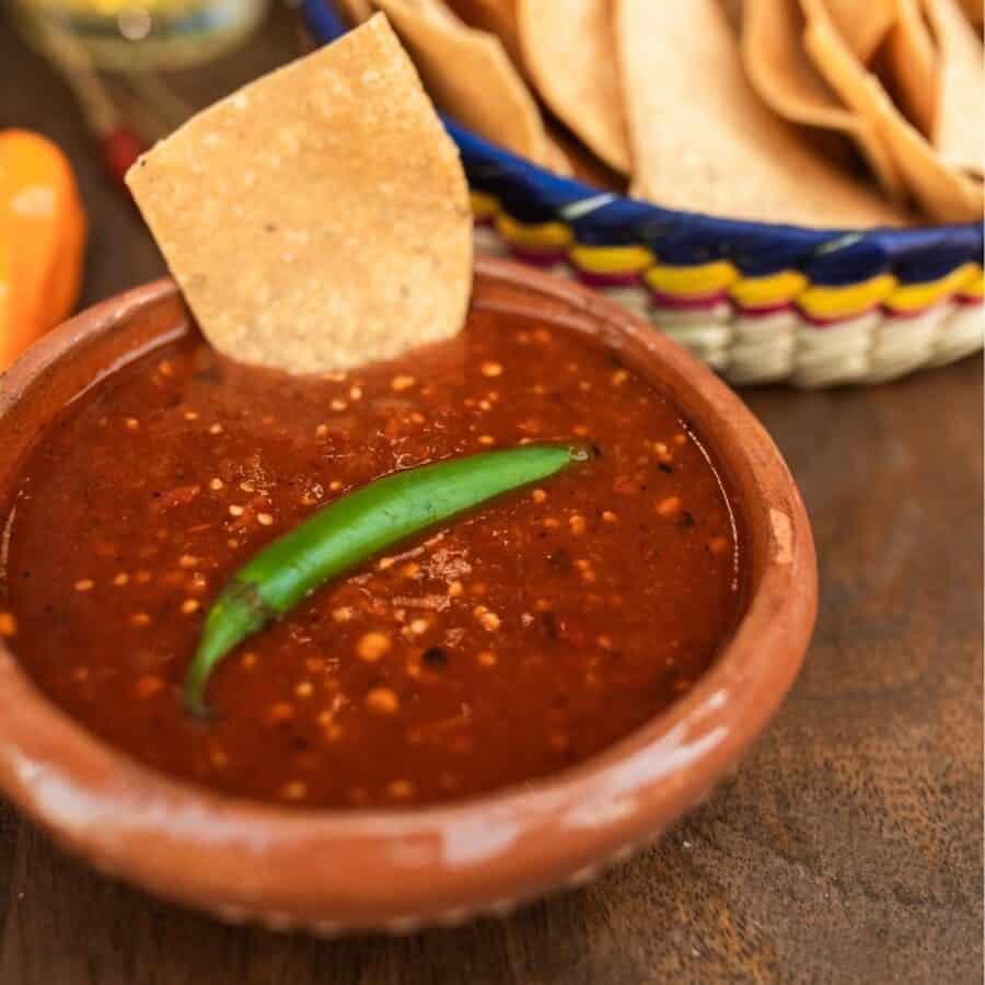 Salsa Roja in a bowl with chips in the background