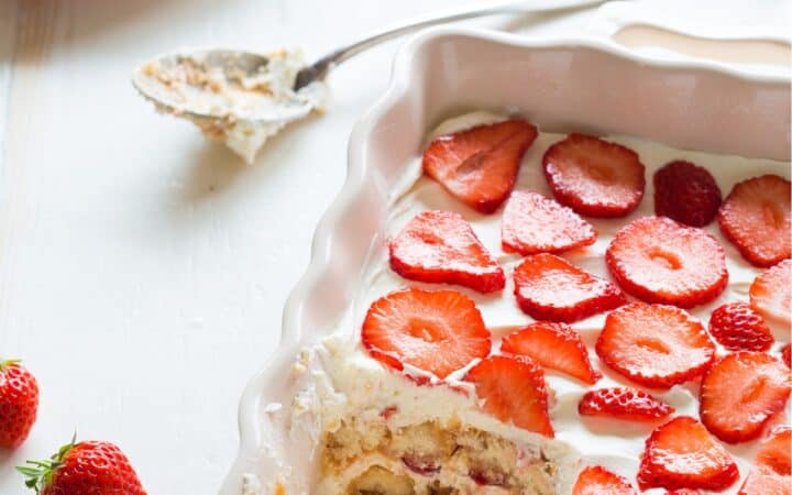 Close up image of Strawberry Tiramisu in a baking dish with a portion missing - 12