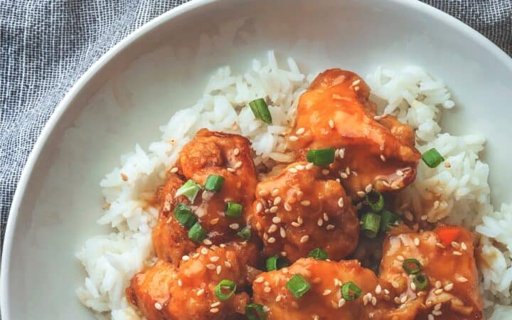 Close up image of Sweet Chili Chicken on a plate with rice and garnish