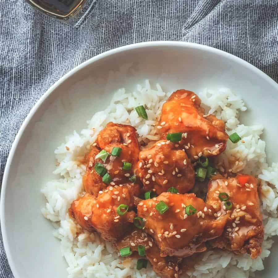 Close up image of Sweet Chili Chicken on a plate with rice and garnish